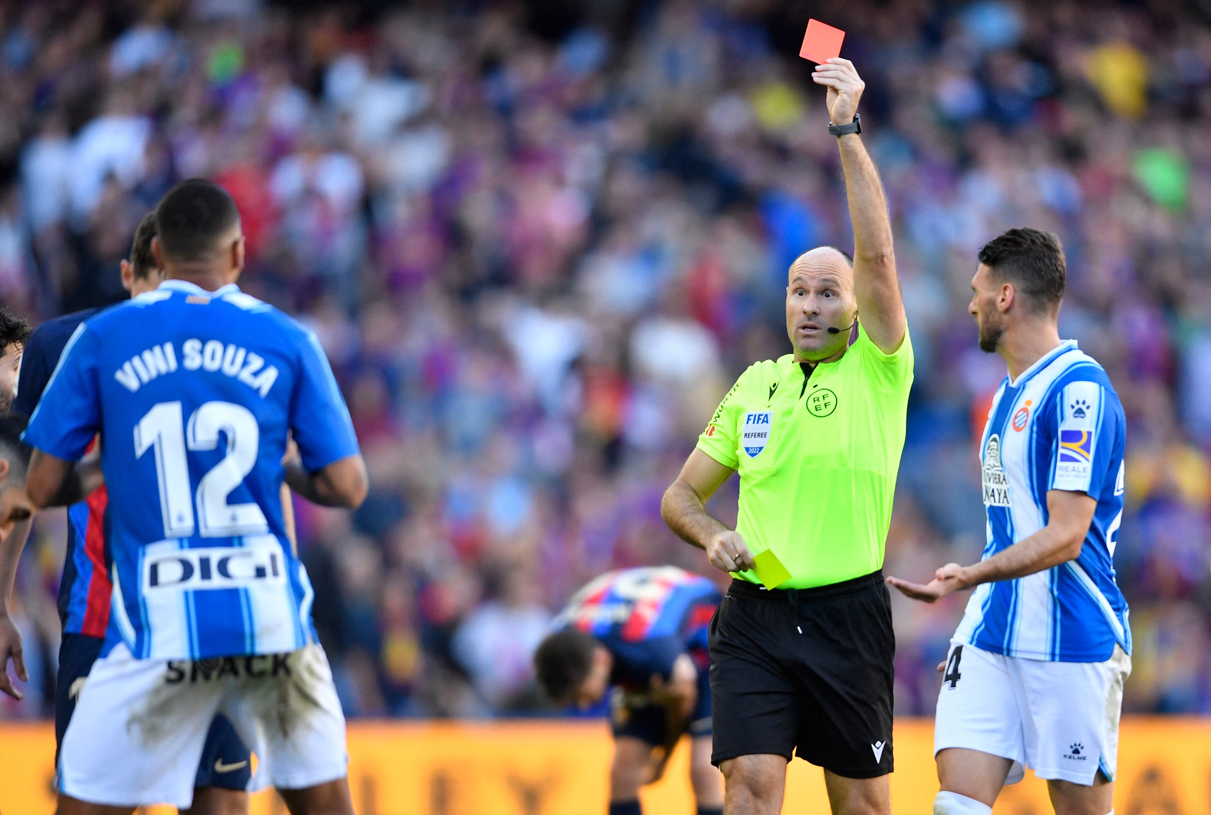 Spanish referee Mateu Lahoz presents a red card to Espanyol's Brazilian midfielder Vinicius Souza during the Spanish League football match between FC Barcelona and RCD Espanyol at the Camp Nou stadium in Barcelona on December 31, 2022. (Photo by Pau BARRENA / AFP)