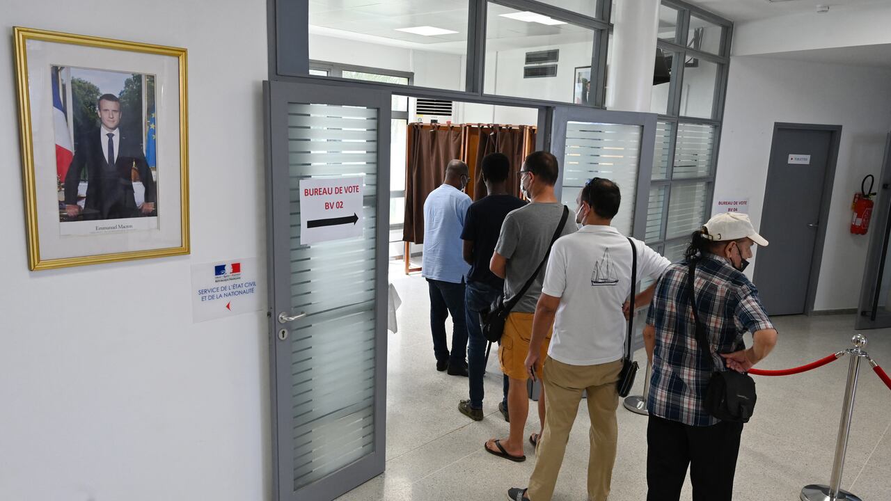 Los ciudadanos franceses hacen cola para emitir sus votos durante la primera ronda de votación en las elecciones presidenciales francesas, en un colegio electoral en el Consulado General de Francia en Abiyán el 10 de abril de 2022. (Foto de Issouf SANOGO / AFP)