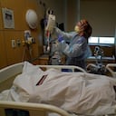 La enfermera Nikki Hollinger limpia una habitación frente al cuerpo de una víctima de covid-19 en un centro médico de Los Ángeles. (AP Foto/Jae C. Hong)