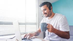 Portrait of a happy Latin American man working online at home using his laptop and smiling â telework concepts