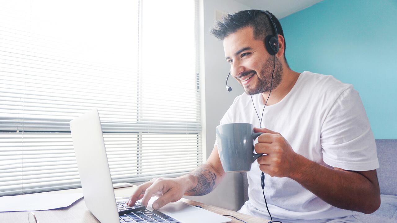 Portrait of a happy Latin American man working online at home using his laptop and smiling â telework concepts