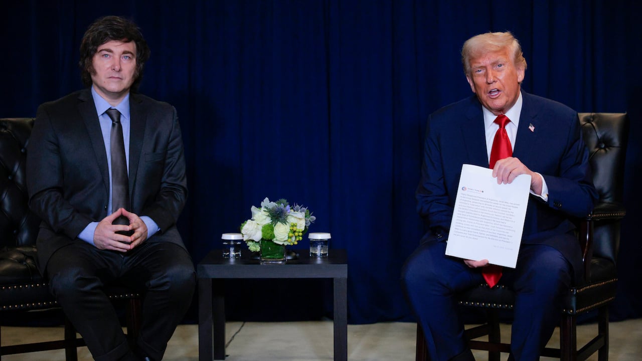 El presidente de Estados Unidos, Donald Trump (der.), sostiene una copia impresa de su publicación en redes sociales mientras conversa con el presidente de Argentina, Javier Milei, durante una reunión bilateral en el marco del 80.º periodo de sesiones de la Asamblea General de las Naciones Unidas (AGNU) en la sede de las Naciones Unidas el 23 de septiembre de 2025 en la ciudad de Nueva York.