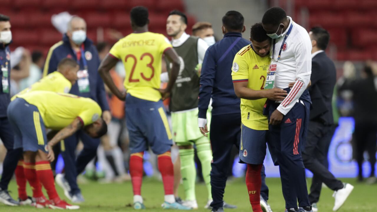 Colombia's Yimmi Chara, second right, is comfort by a member of the team after Argentina defeated Colombia in a penalty shootout during a Copa America semifinal soccer match at the National stadium in Brasilia, Brazil, Wednesday, July 7, 2021. (AP Photo/Eraldo Peres)