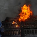 Un trabajador municipal con traje de protección personal realiza los últimos ritos durante la cremación de una víctima de COVID-19 en Vasai, en las afueras de Mumbai, India. (Foto AP / Rafiq Maqbool)