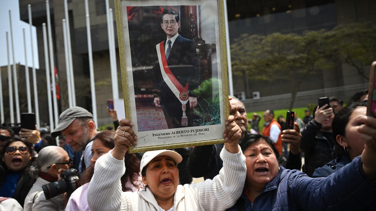 Los partidarios del difunto ex presidente de Perú, Alberto Fujimori, esperan a que su coche pase hacia el Ministerio de Cultura para su velorio en Lima el 12 de septiembre de 2024. El ex presidente de Perú, Alberto Fujimori, quien gobernó su país con puño de hierro y luego pasó 16 años en prisión por crímenes de lesa humanidad, falleció el miércoles a los 86 años en la capital Lima. (Foto de ERNESTO BENAVIDES/AFP)
