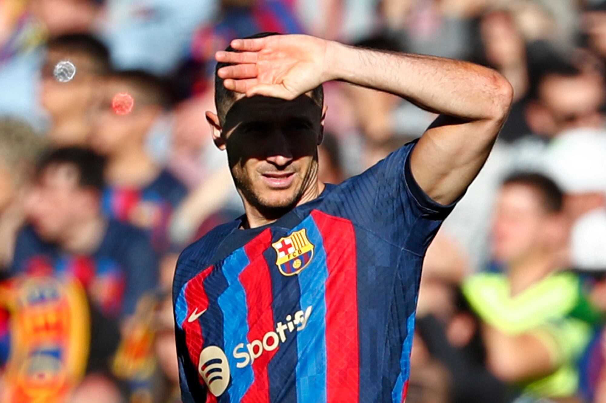 Barcelona's Robert Lewandowski shields his eyes from the sun during a Spanish La Liga soccer derby match between Barcelona and Espanyol at the Camp Nou stadium in Barcelona, Spain, Saturday, Dec. 31, 2022. (AP Photo/Joan Monfort)