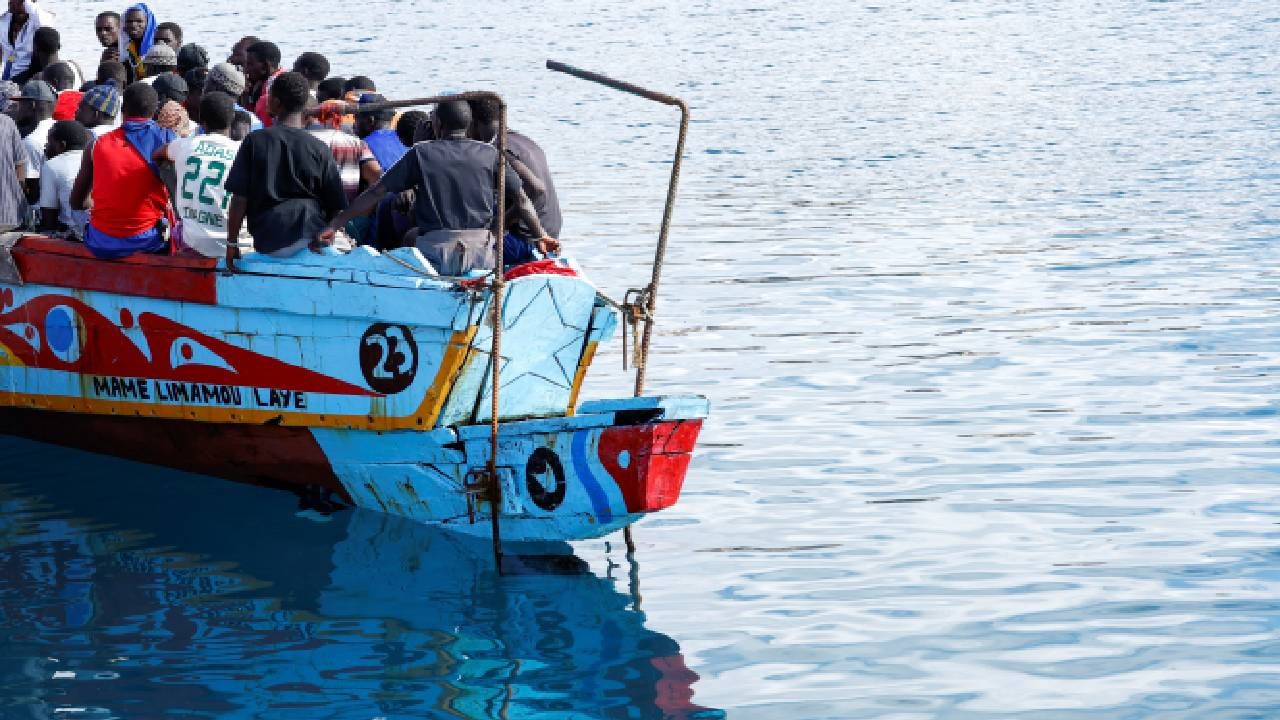 Migrantes esperan desembarcar en el puerto de Arguineguín, España.