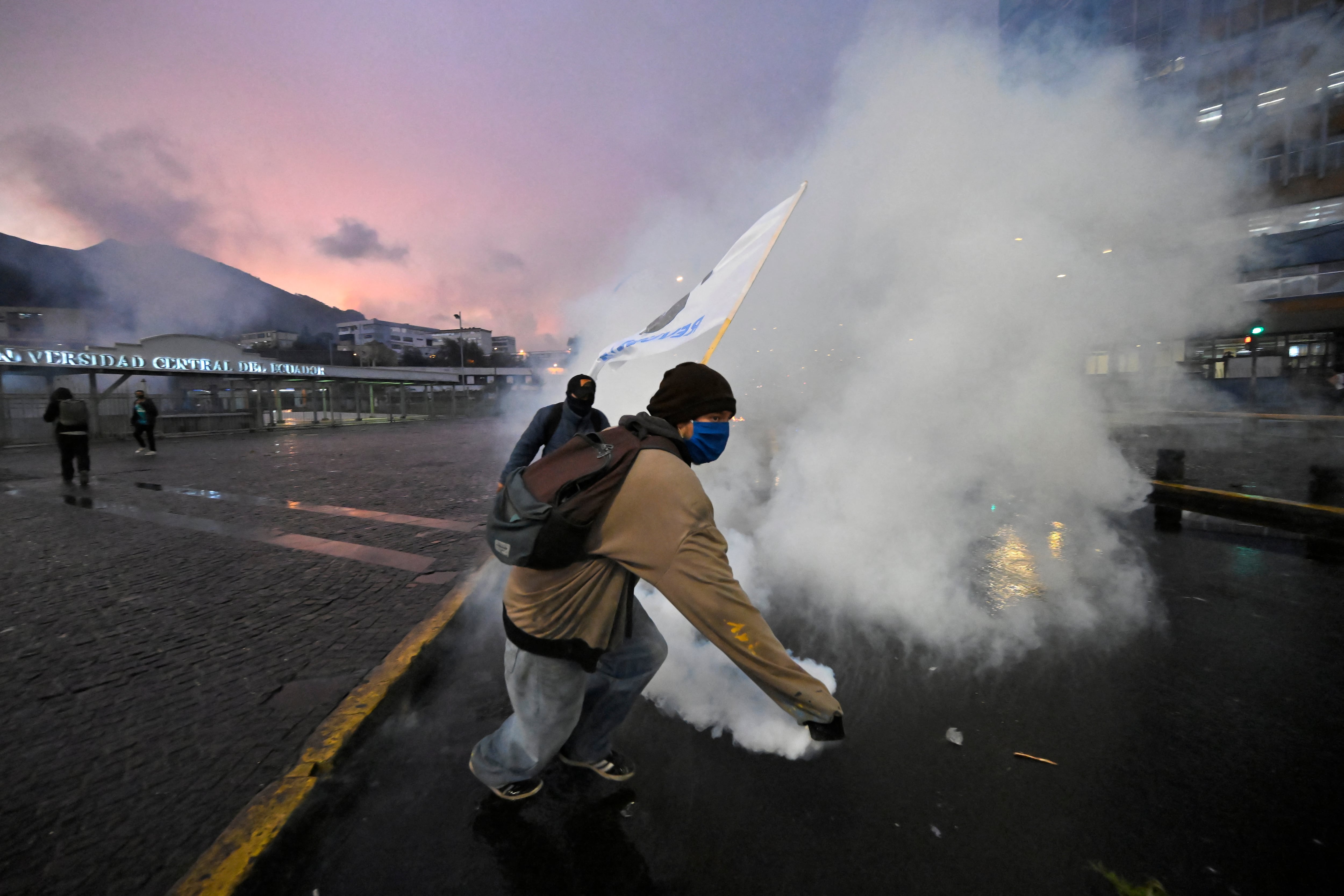 Un manifestante agarra una bomba lacrimógena mientras se enfrenta a agentes de la policía antidisturbios durante una protesta antigubernamental en apoyo al paro nacional convocado por la CONAIE (la mayor organización indígena de Ecuador).