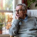 Senior man looking out of window at home