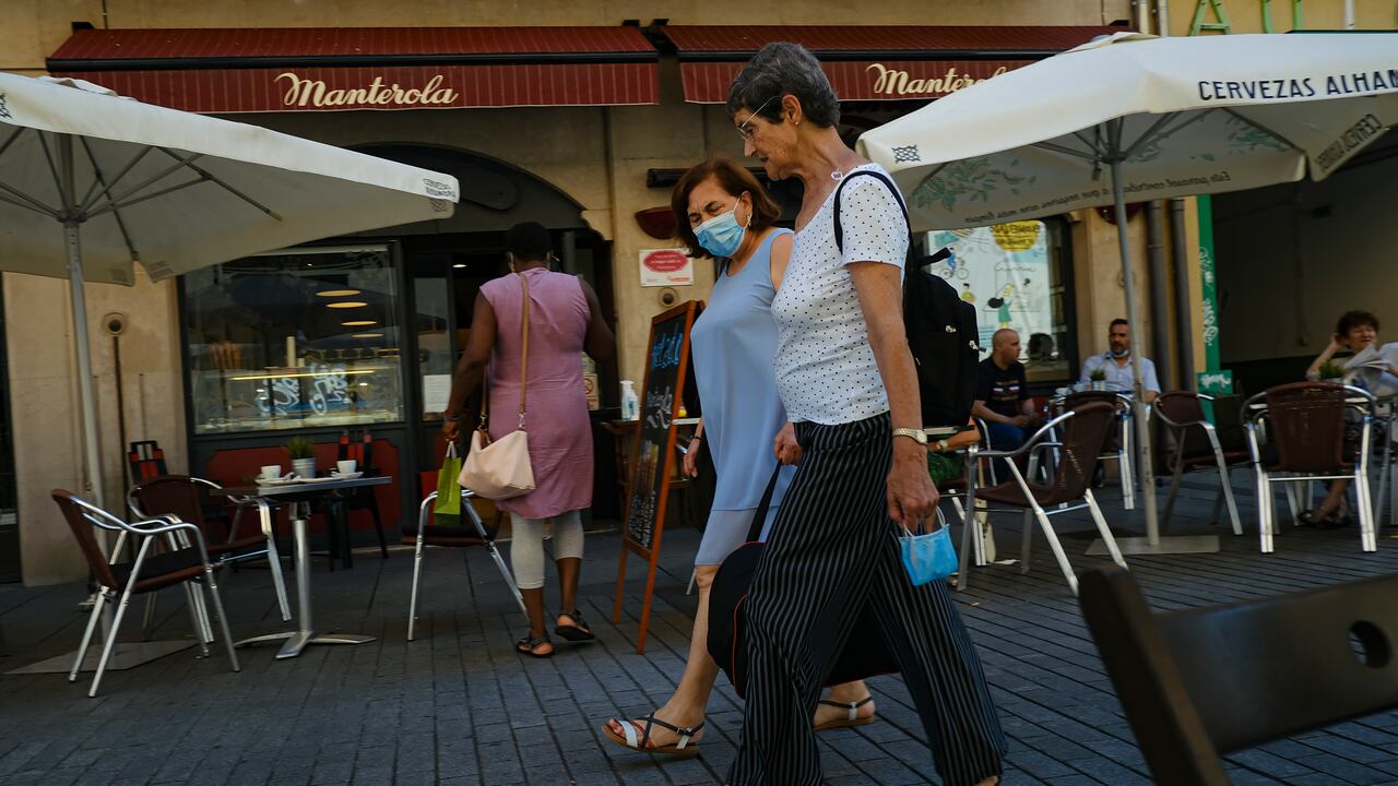 Dos mujeres caminan cerca de un bar en Pamplona, norte de España, el 5 de julio de 2021. (AP Foto/Alvaro Barrientos)