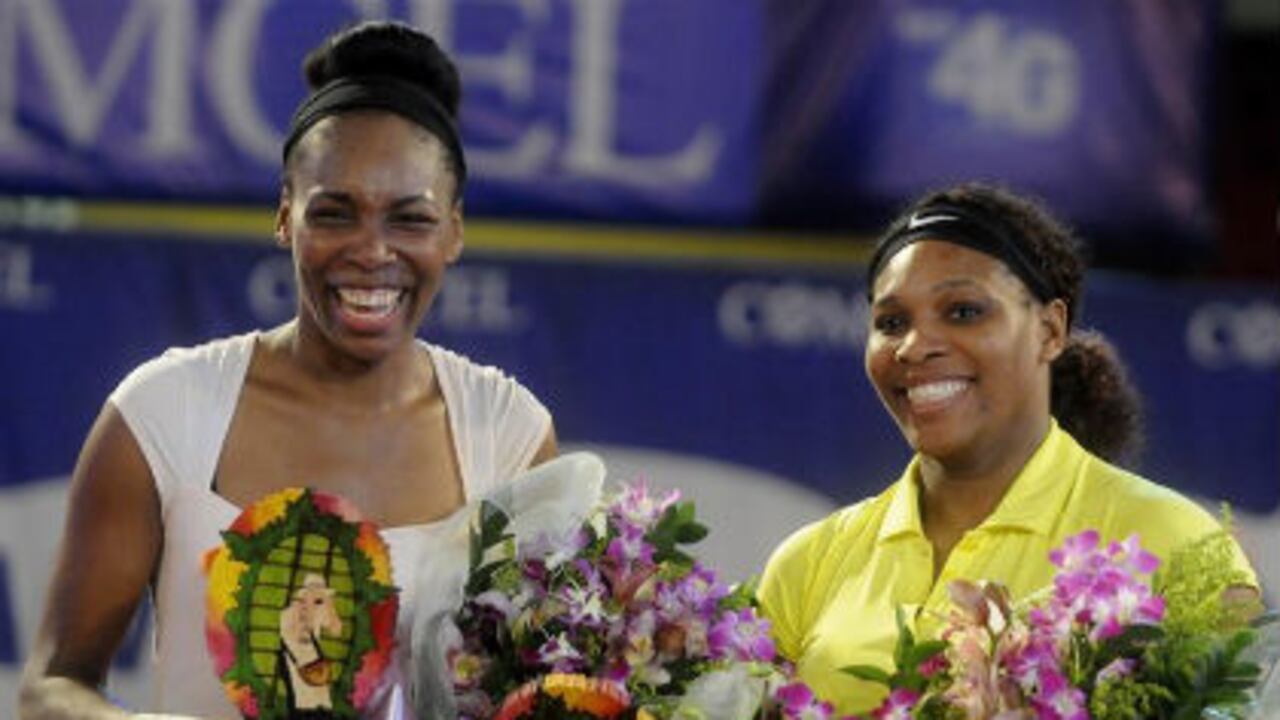 Las tenistas estadounidenses Serena Williams (i) y Venus Williams (d) reciben los trofeos que se les entregaron después del partido de exhibición, el miércoles, en Medellín.