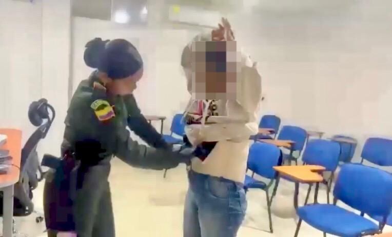 Momento en el que una patrullera requisa a la mujer hallando la droga detrás de la faja