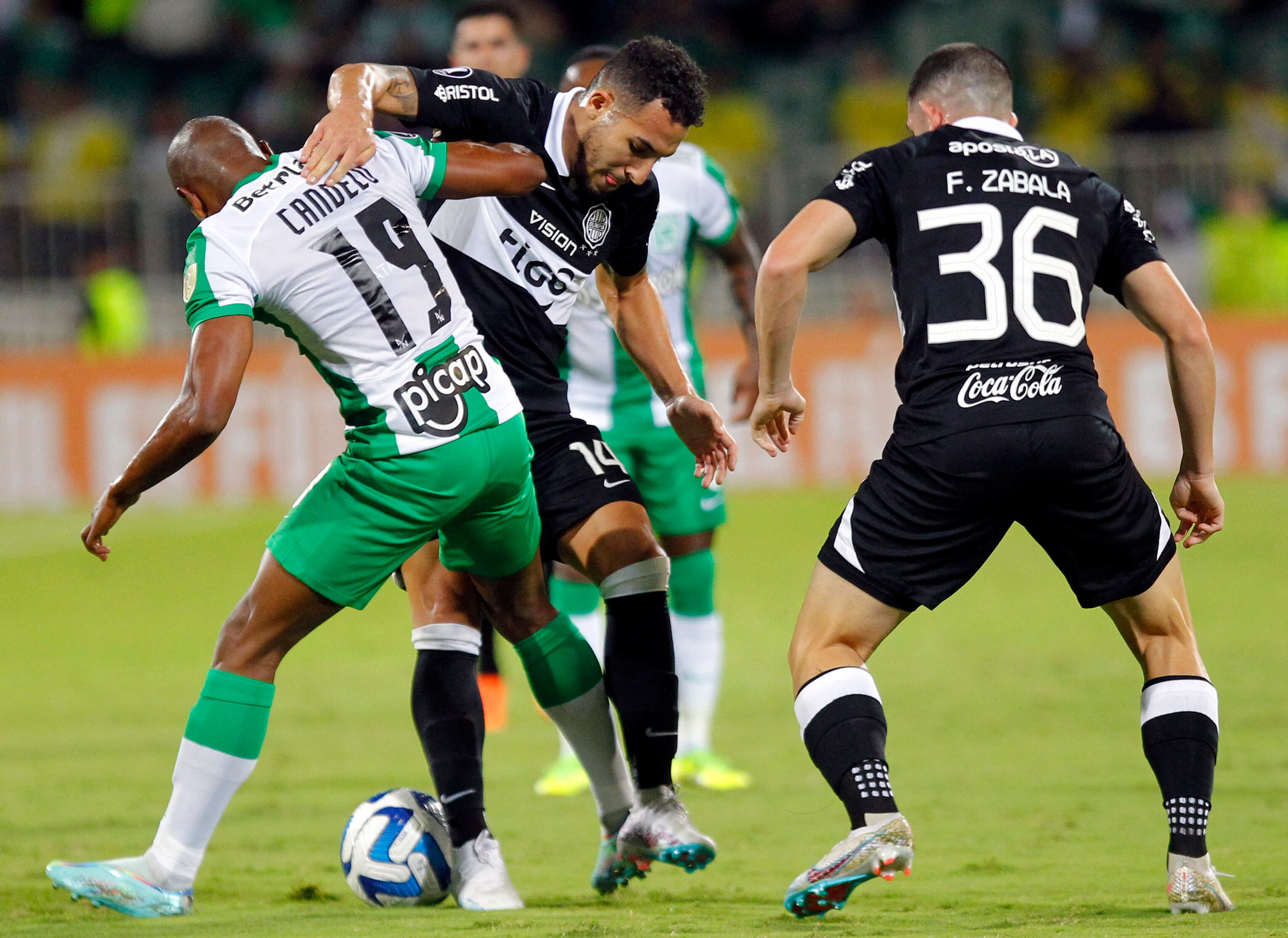 Yerson Candelo disputando un balón con jugador de Olimpia de Paraguay.