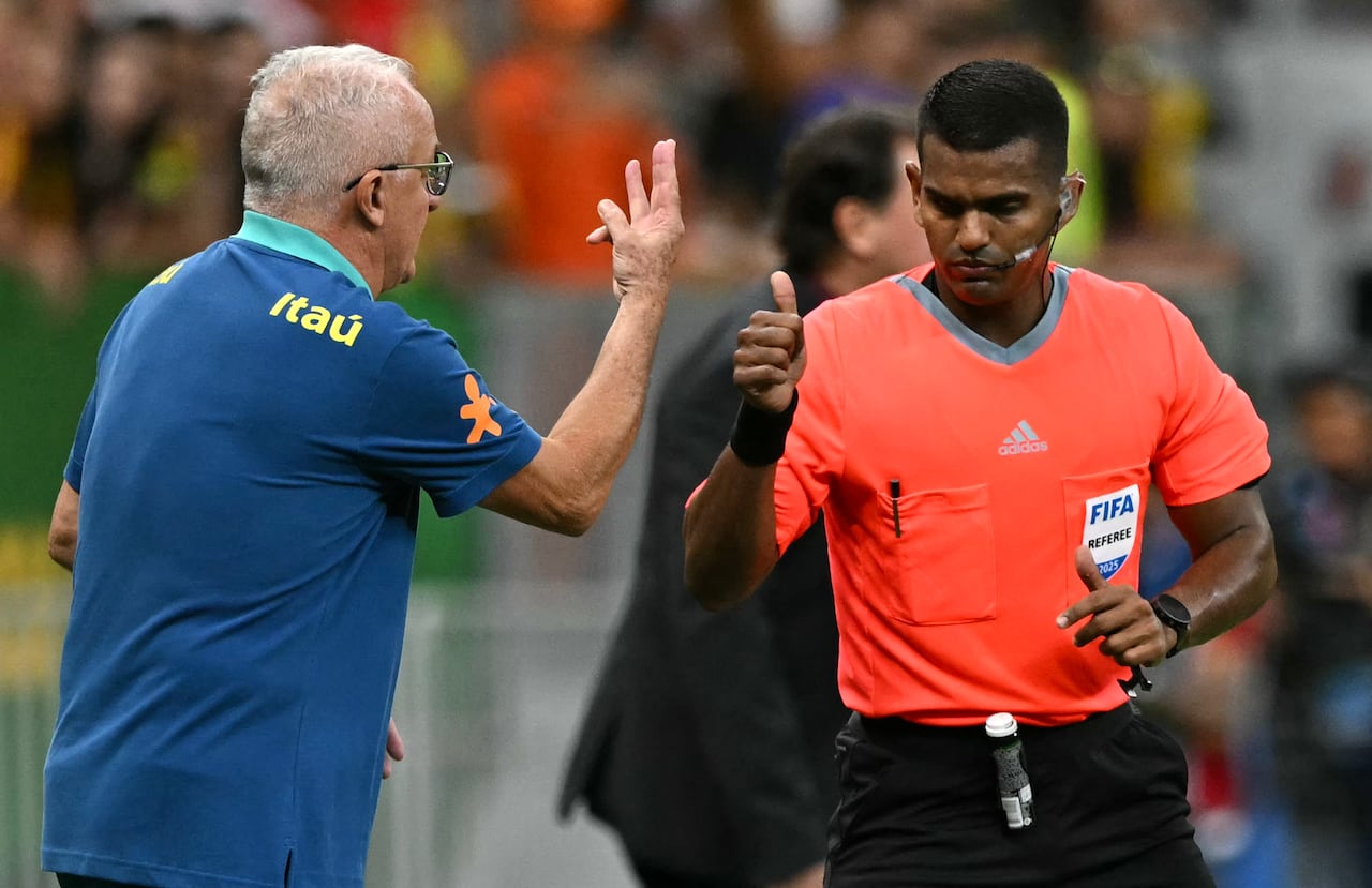 Venezuelan referee Alexis Herrera (R) and Brazil's head coach Dorival Junior gesture during the 2026 FIFA World Cup South American qualifiers football match between Brazil and Colombia, at the Mane Garrincha stadium in Brasilia, on March 20, 2025. (Photo by EVARISTO SA / AFP)