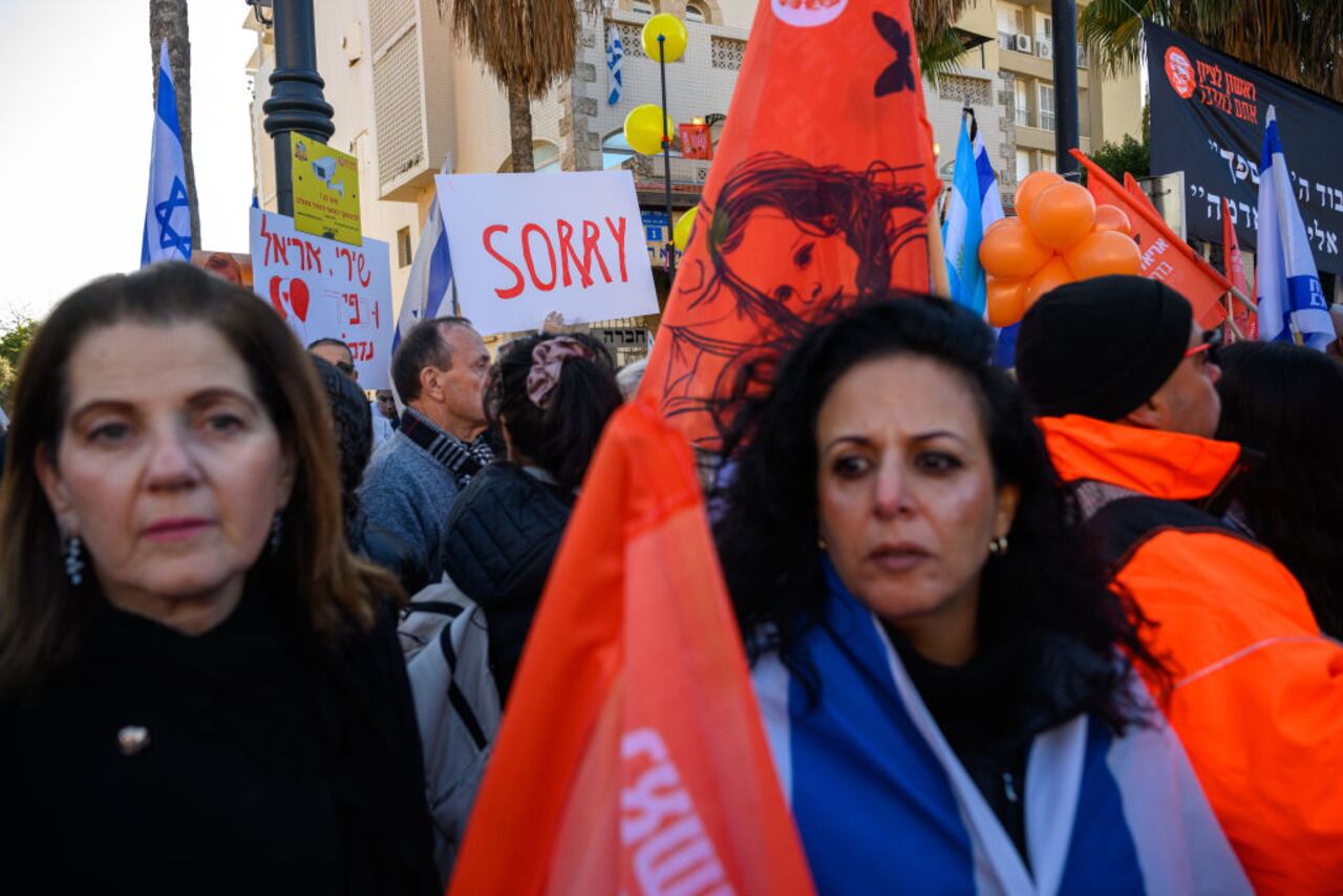 RISHON LEZION, ISRAEL - FEBRUARY 26: Thousands of people line the street to watch and pay their respects as the funeral procession carrying the caskets of Shiri Bibas, Kfir Bibas and Ariel Bibas pass by with the family in minibuses behind them on its way to the funeral on February 26, 2025 in Rishon LeZion, Israel. A funeral is being held for former hostages Shiri Bibas and her two young sons, Ariel and Kfir, whose bodies were returned to Israel from Gaza last week. At the time of their abduction from Kibbutz Nir Oz on October 7, 2023, Shiri was 32, Ariel was four, and Kfir was nine months old. Their father, Yarden Bibas, 34, was also taken by Hamas militants, but was released alive as part of the ceasefire agreement on 1 February. (Photo by Alexi J. Rosenfeld/Getty Images)