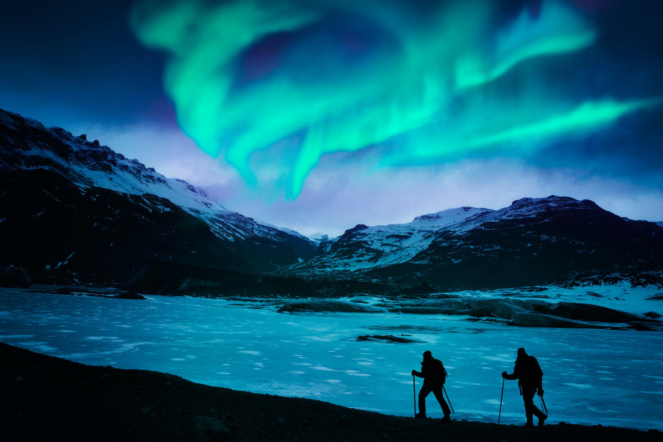 Excursionistas bajo la aurora boreal en Islandia