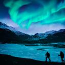 Excursionistas bajo la aurora boreal en Islandia