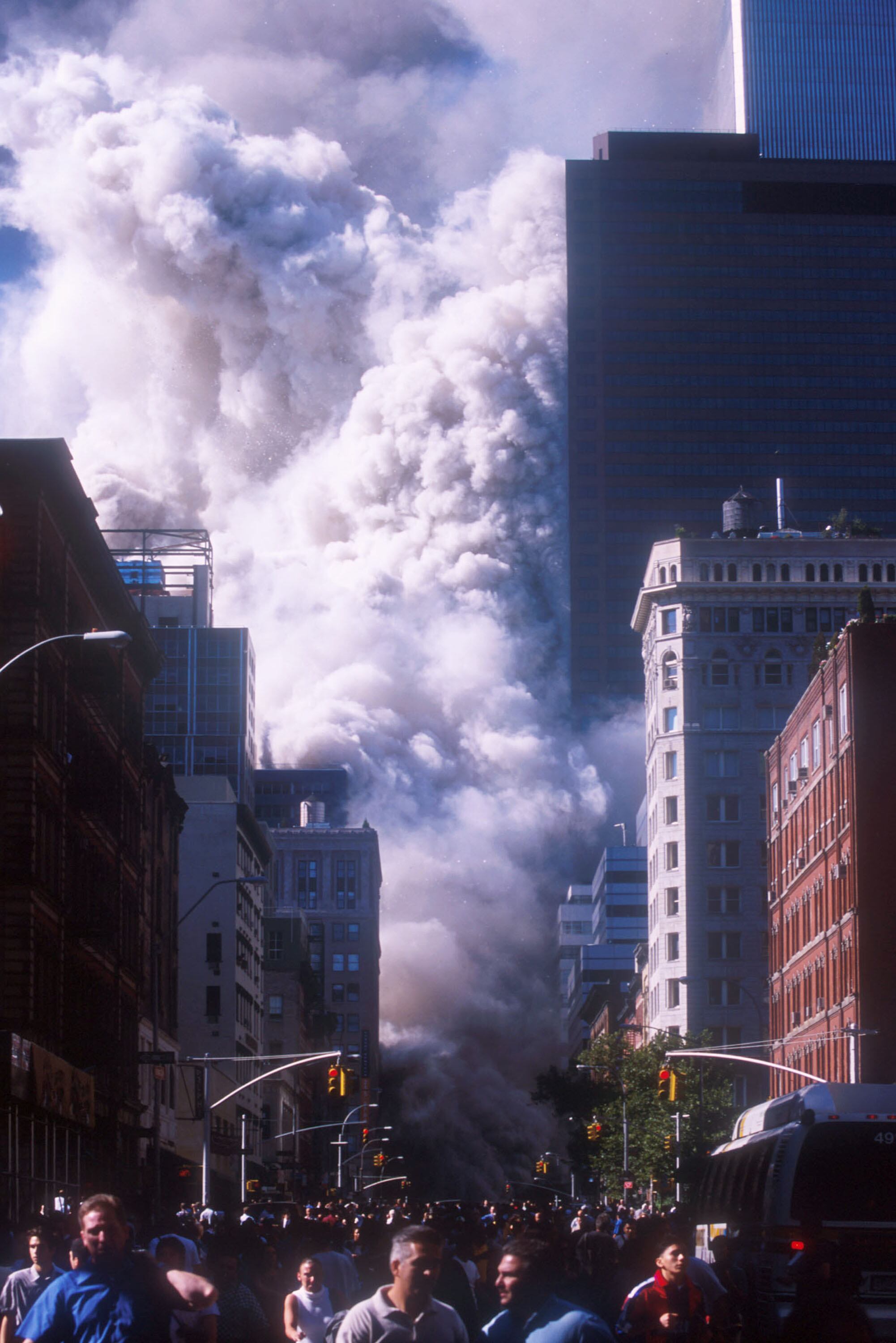 People run away from the World Trade Center's twin towers after they collapsed following being struck by a commerical airliner in a suspected terrorist attack September 11, 2001 in New York City. (Photo by Ezra Shaw/Getty Images)