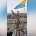un hombre vestido con ropa militar gesticula junto a una bandera ucraniana en Kalynivske, en la región de Jersón, Ucrania, el 9 de noviembre de 2022 en esta captura de pantalla tomada de un video. Video obtenido por Reuters el 10 de noviembre de 2022