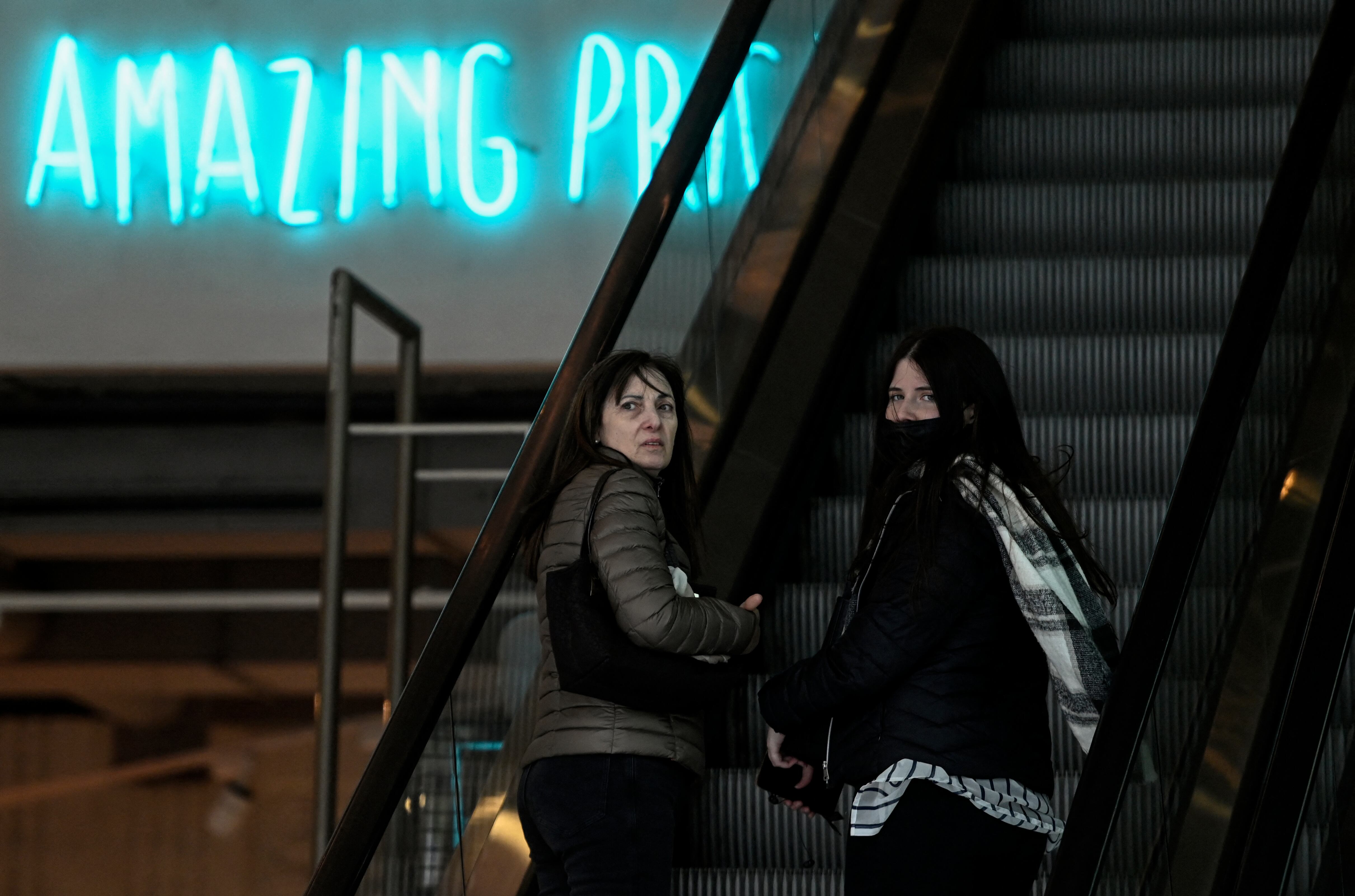 Los clientes sin tapabocas se ven en una tienda en Madrid el 20 de abril de 2022 cuando se levanta el mandato de máscara anti-Covid en interiores en España, excepto en hospitales y en el transporte público.