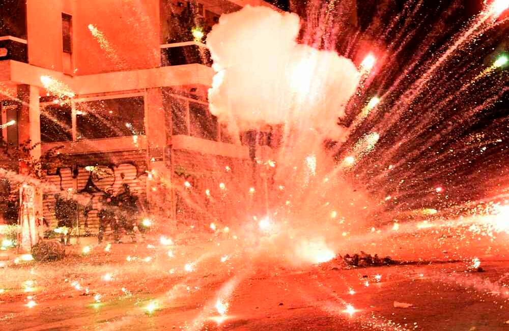Un fuego artificial explota en la policía antidisturbios durante los enfrentamientos con manifestantes en el centro de Atenas el 6 de diciembre de 2017, después de una manifestación en conmemoración de Alexis Grigoropoulos, de 15 años, quien fue asesinado a tiros por un oficial de policía en 2008. En Atenas durante las protestas anuales en recuerdo del adolescente asesinado por la policía en 2008. ARIS MESSINIS / AFP