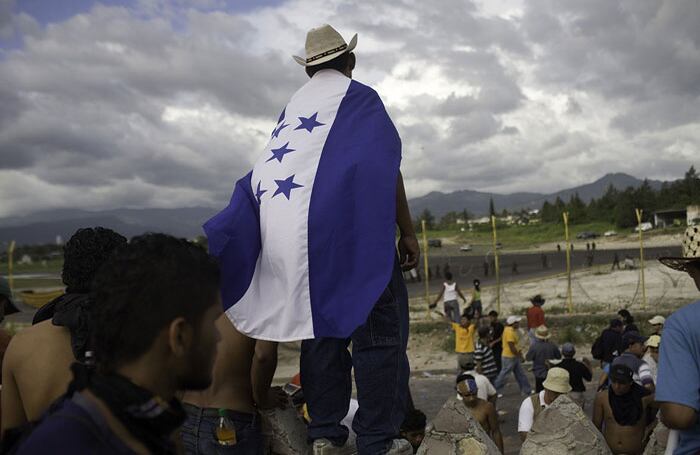 Los hondureños partidarios del derrocado presidente Manuel Zelaya iniciaron su protesta con la firme intención de mantenerse unidos y pacíficos arropados con la bandera.