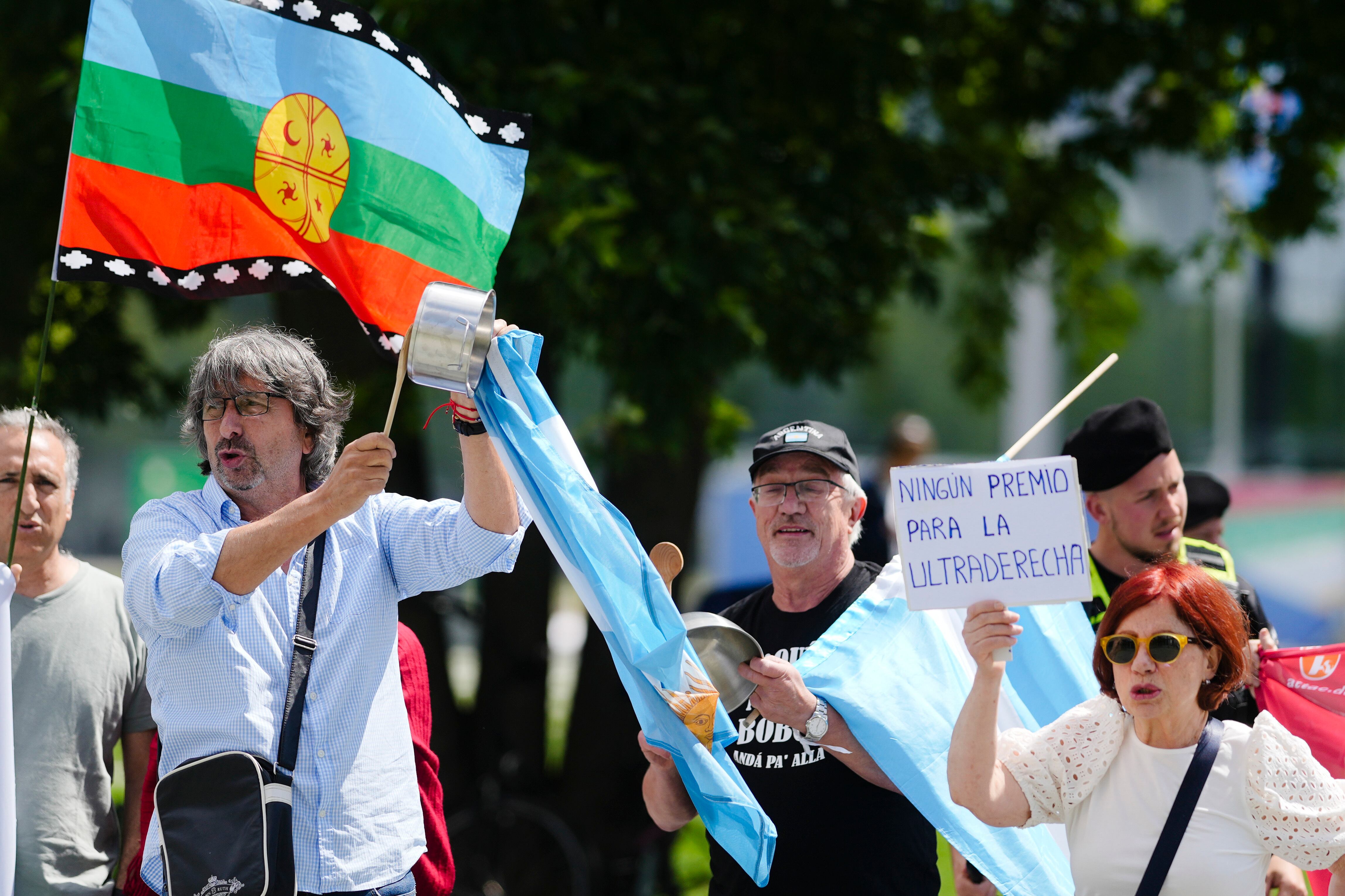 Los manifestantes muestran pancartas y carteles mientras protestan contra la visita del presidente argentino Javier Milei a una reunión con el canciller alemán Olaf Scholz en Berlín, Alemania, el domingo 23 de junio de 2024. La pancarta dice: Milei por la mano, no a la ley básica. El cartel dice: "No hay subsidio para la ultraderecha". (Foto AP/Markus Schreiber)