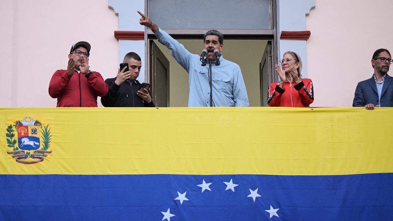 El presidente venezolano, Nicolás Maduro (C), acompañado por su esposa Cilia Flores (C-R), pronuncia un discurso ante sus seguidores durante una manifestación en el palacio presidencial de Miraflores en Caracas el 1 de agosto de 2024. El presidente de Venezuela, Nicolás Maduro, propuso este jueves "retomar" las negociaciones con Estados Unidos, país que no reconoció su reelección y apoya las acusaciones de fraude de la oposición. (Foto de Yuri CORTEZ / AFP)