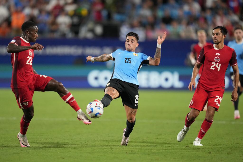 CHARLOTTE, NORTH CAROLINA - JULY 13: Cristian Olivera of Uruguay and Richie Laryea of Canada battle for the ball during the CONMEBOL Copa America 2024 third place match between Uruguay and Canada at Bank of America Stadium on July 13, 2024 in Charlotte, North Carolina. (Photo by Grant Halverson/Getty Images)
