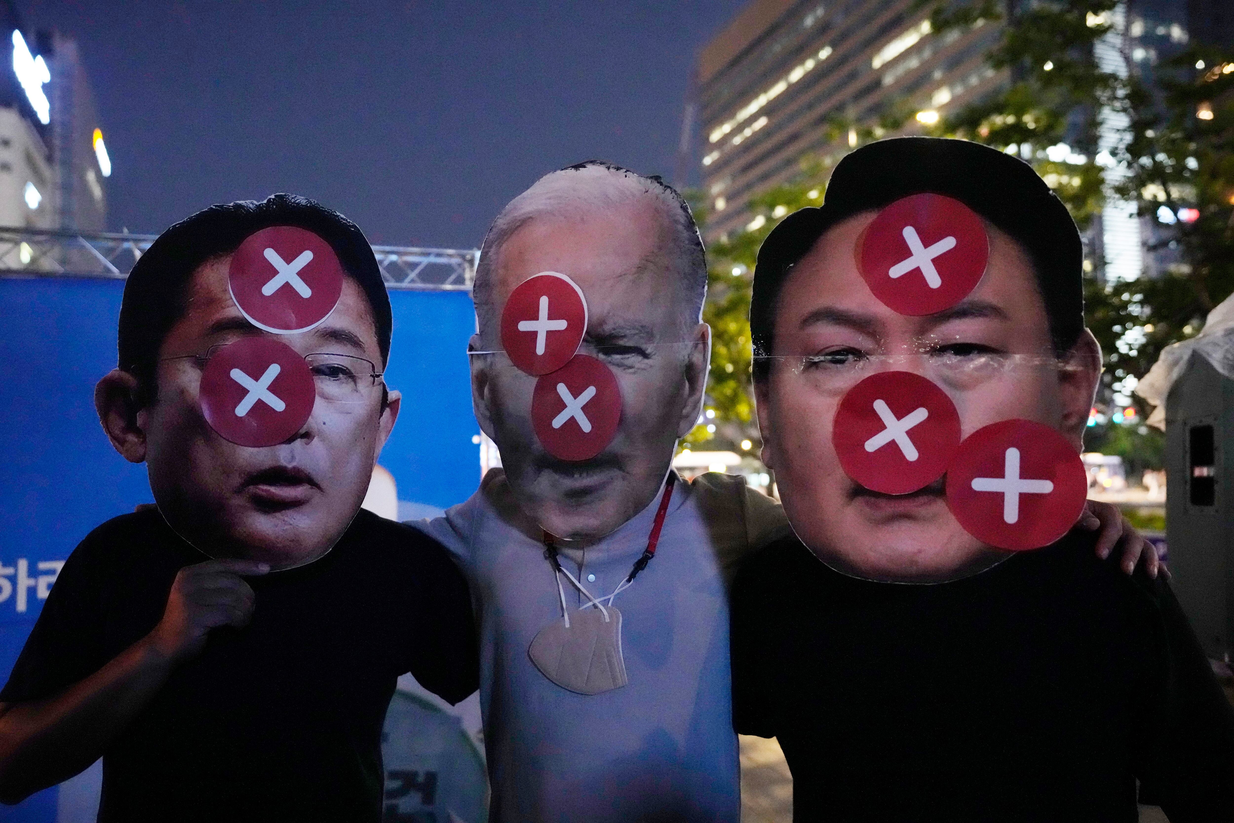 Los manifestantes usan máscaras desfiguradas del primer ministro japonés Fumio Kishida, a la izquierda, el presidente de los Estados Unidos, Joe Biden, y el presidente de Corea del Sur, Yoon Suk Yeol, a la derecha, durante una manifestación contra la cooperación militar entre Corea del Sur, Estados Unidos y Japón en Seúl, Corea del Sur