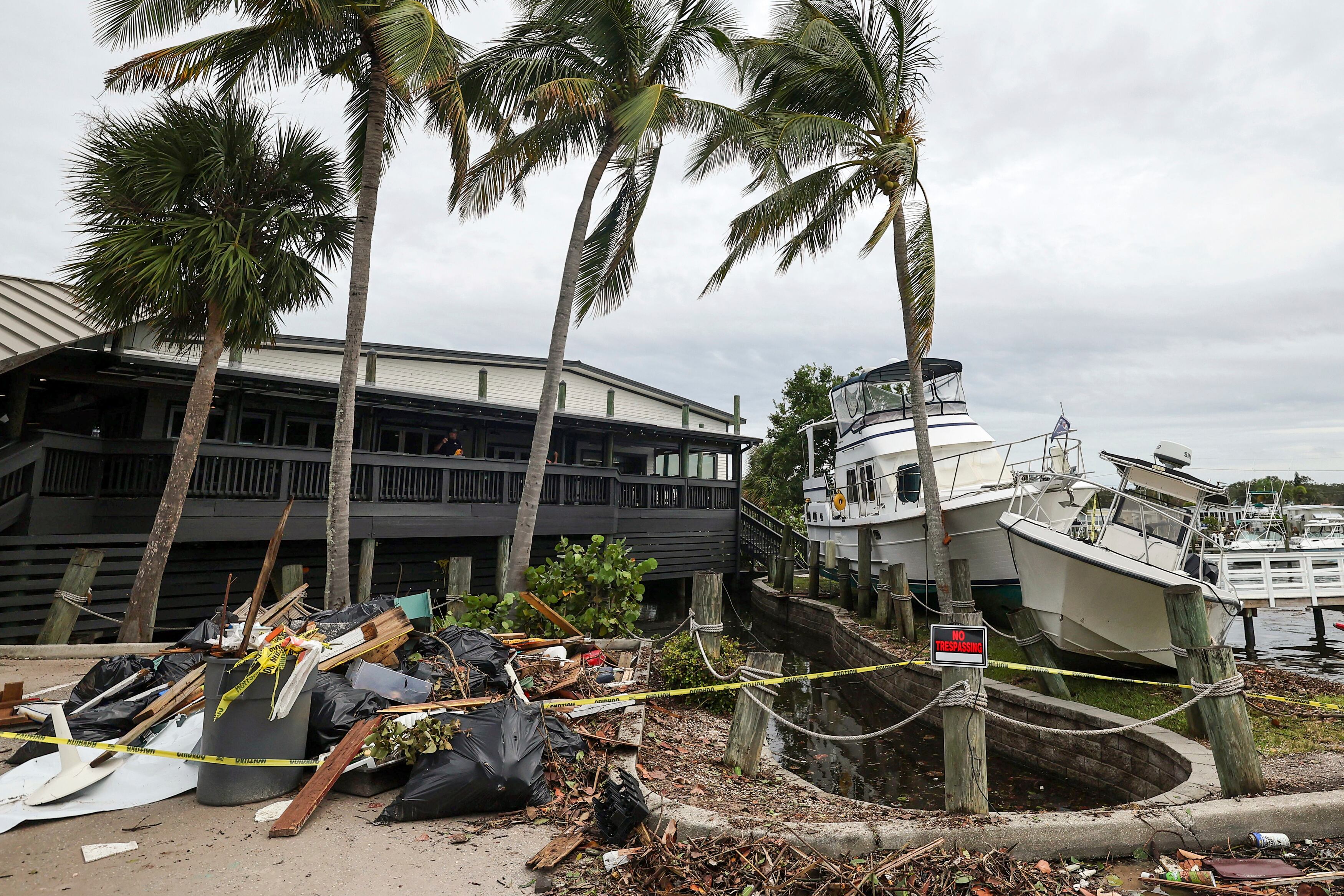 Barcos descansan junto a un restaurante después de ser empujados hacia arriba por las inundaciones del huracán Helene el sábado 28 de septiembre de 2024 en San Petersburgo, Florida (Foto AP/Mike Carlson)