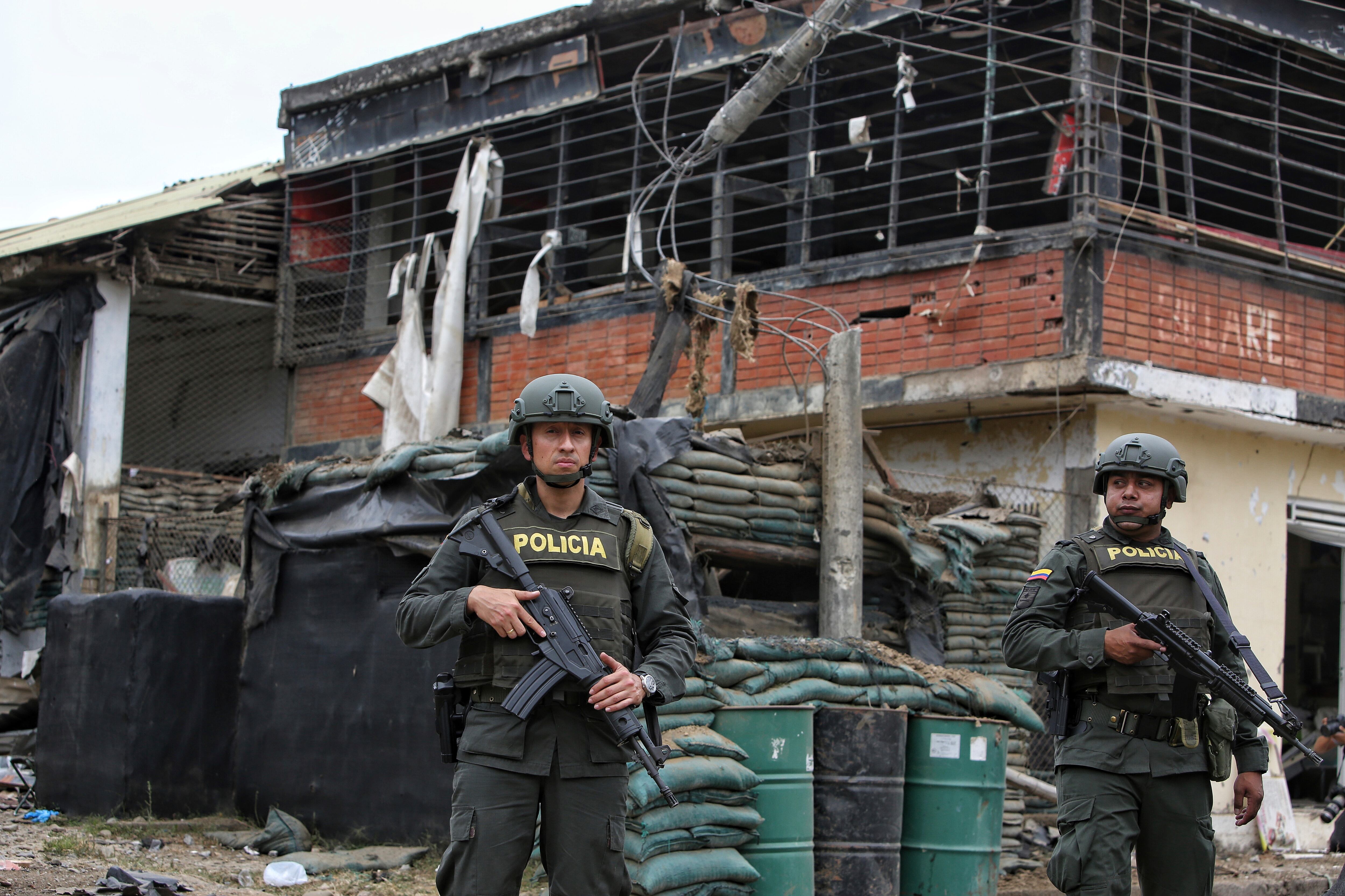 Police stand guard before a damaged police station after a car bomb exploded, in Timba, Cauca, Colombia, Sunday, Aug. 13, 2023. According to police, the car bomb killed one police officer. (AP Photo/Andres Quintero)