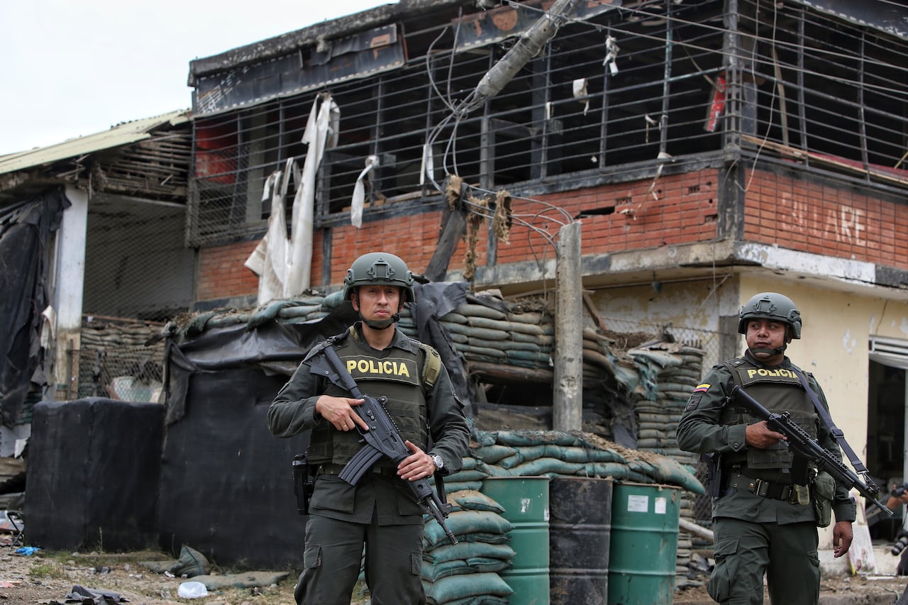 Police stand guard before a damaged police station after a car bomb exploded, in Timba, Cauca, Colombia, Sunday, Aug. 13, 2023. According to police, the car bomb killed one police officer. (AP Photo/Andres Quintero)