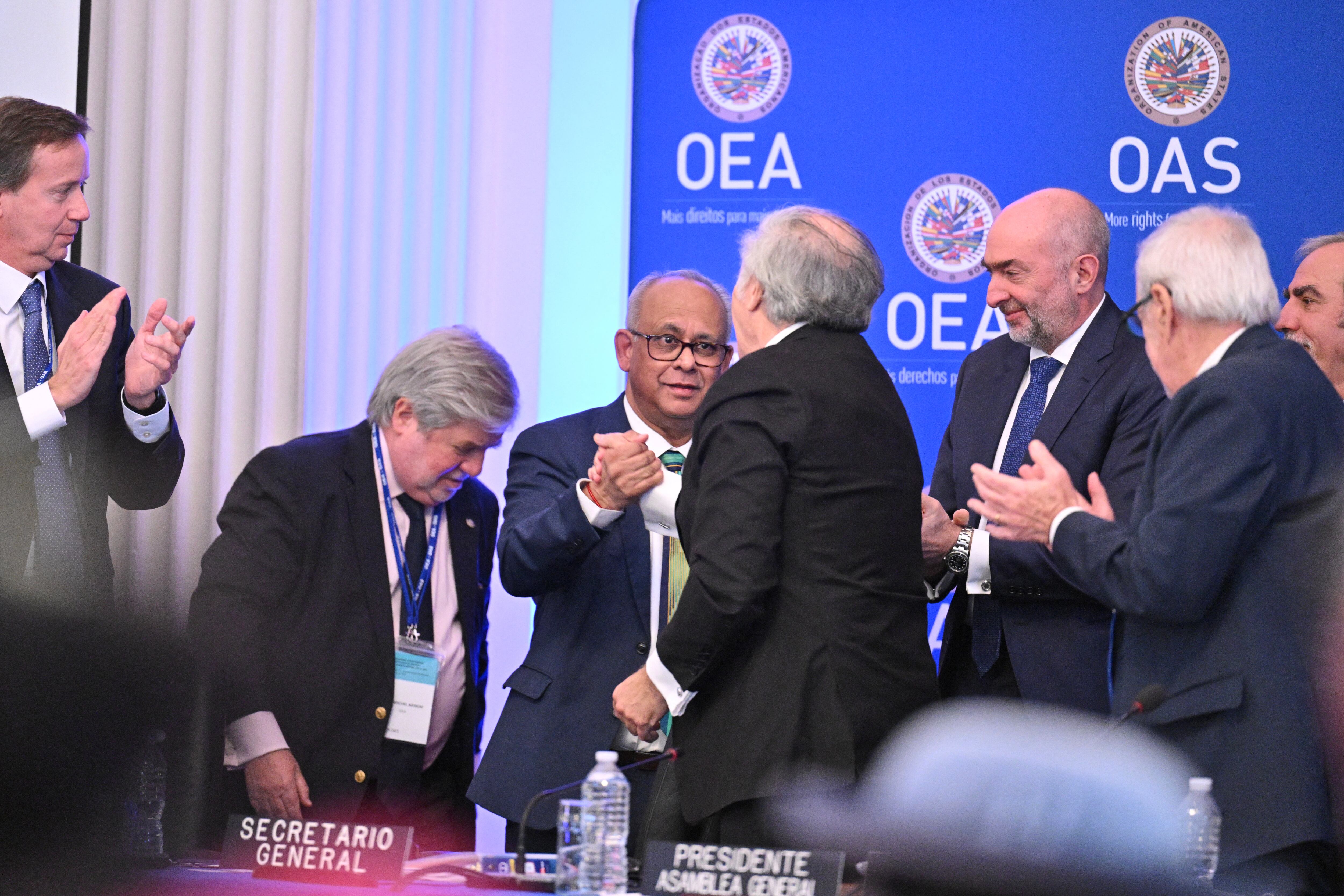 El Secretario General saliente de la OEA, Luis Almagro (centro-der.), saluda al Secretario General electo de la OEA, Albert Ramdin, durante una Asamblea General Especial de la Organización de los Estados Americanos (OEA) para elegir al nuevo Secretario General