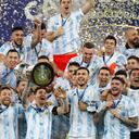 El argentino Lionel Messi, centro, sostiene el trofeo mientras celebra con sus compañeros de equipo después de vencer 1-0 a Brasil en la final de la Copa América en el estadio Maracaná de Río de Janeiro, Brasil, el sábado 10 de julio de 2021 (AP Photo / Andre Penner)