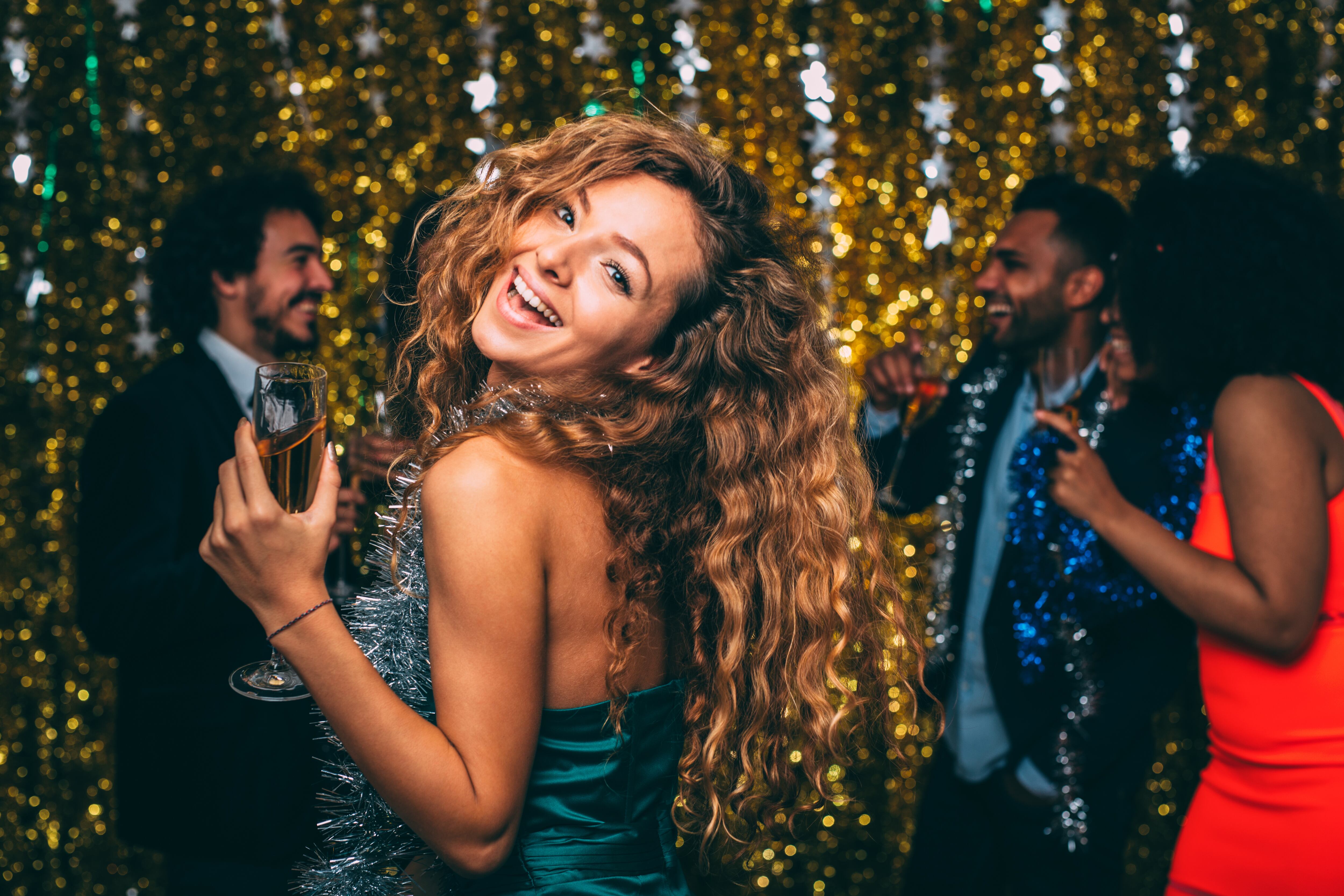 A portrait of a woman celebrating New Year's Eve with friends.
