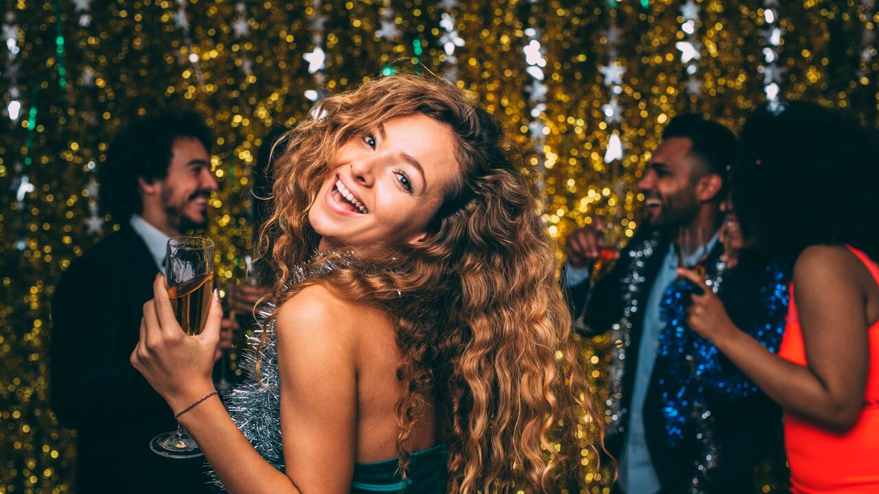 A portrait of a woman celebrating New Year's Eve with friends.