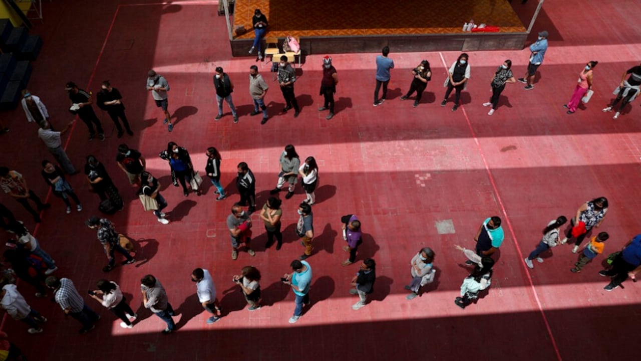 La gente espera su turno para votar durante un referéndum en Chile para decidir si el país debe reemplazar su constitución de 40 años de antigüedad, redactada durante la última dictadura militar, en Santiago de Chile, el domingo 25 de octubre de 2020. (AP Foto/Esteban Félix)