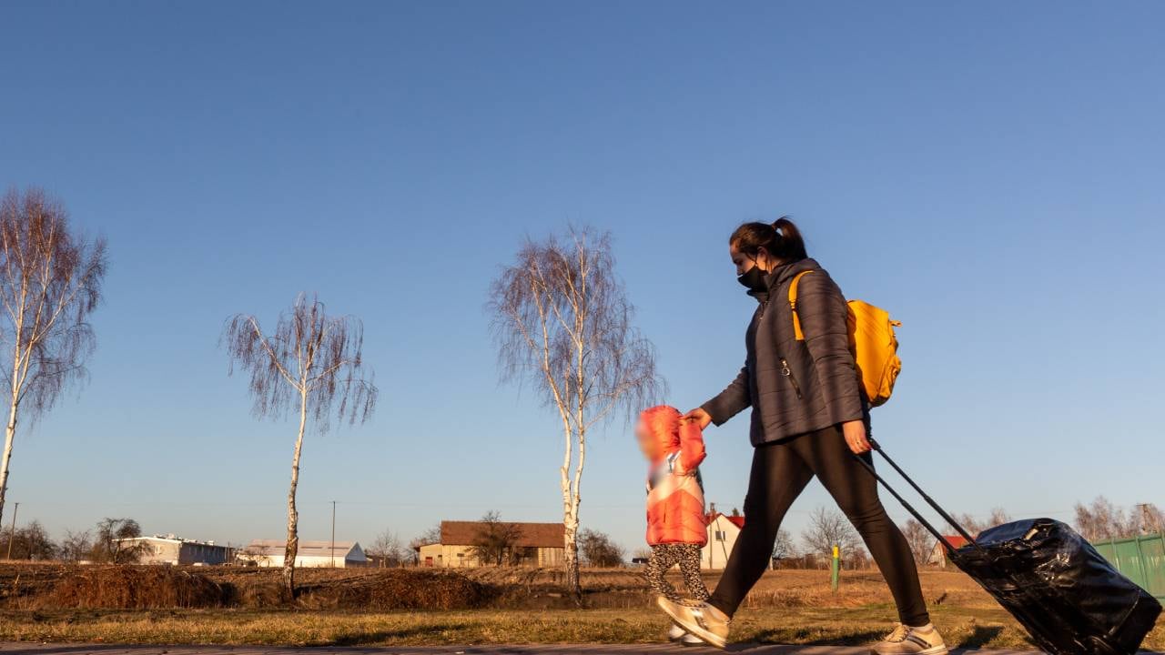 Una madre ucraniana atraviesa el paso fronterizo mientras los primeros migrantes de Ucrania entran en Polonia después de que Rusia bombardeara el territorio ucraniano. Foto: Dominika Zarzycka/NurPhoto vía Getty Images.
