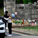 Ivy Huesmann abraza a la oficial de policía de Metro Nashville, Angeline Comilla, antes de visitar el monumento improvisado en la entrada de la Escuela Covenant el martes 28 de marzo de 2023 en Nashville, Tennessee. (Mark Zaleski /The Tennessean via AP)