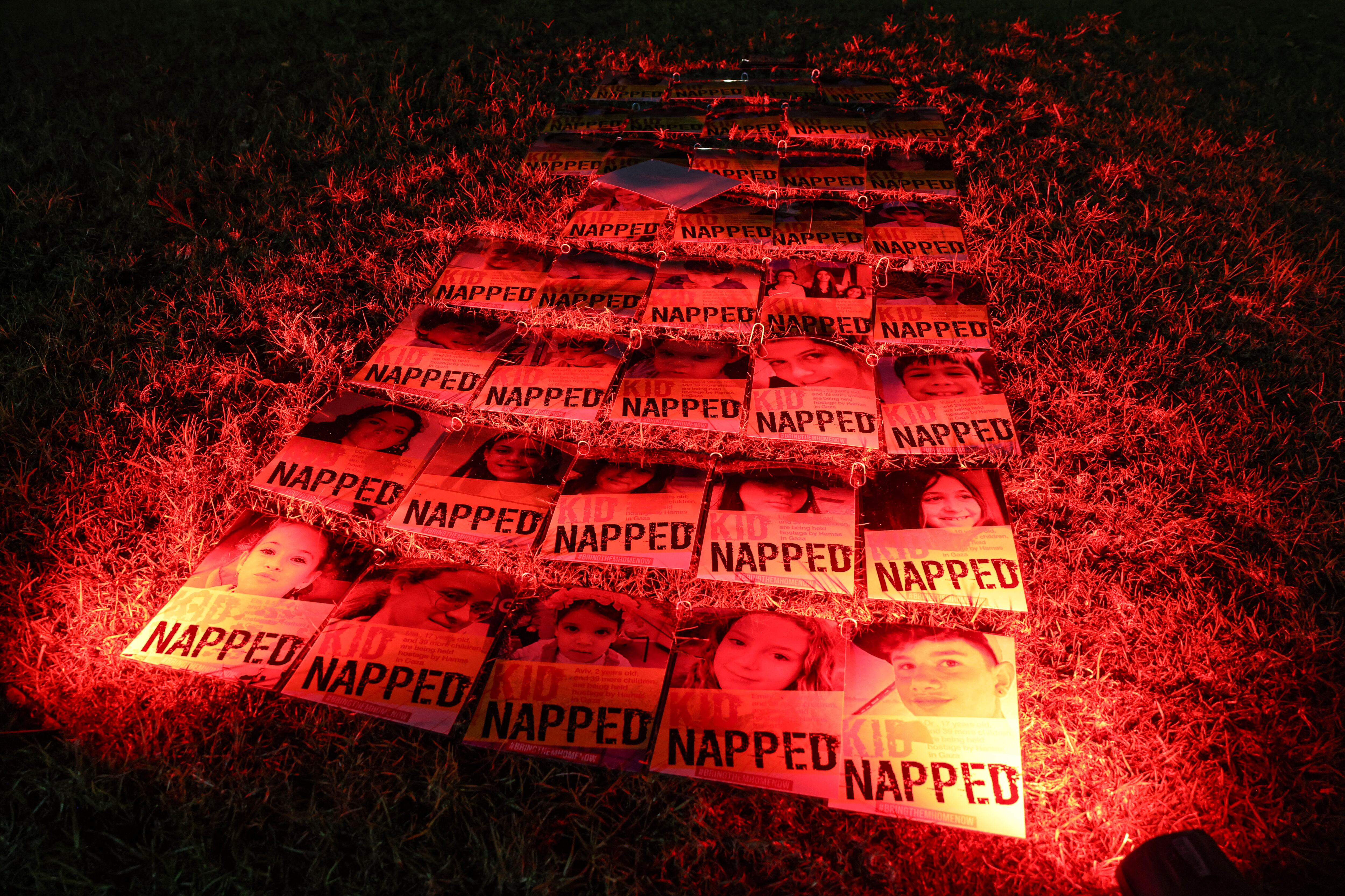 Portraits of Israeli children hostages are displayed during a rally outside the Unicef offices in Tel Aviv on November 20, 2023 to demand the release of Israelis held hostage in Gaza since the October 7 attack by Hamas militants, amid ongoing battles between Israel and the Palestinian armed group. (Photo by AHMAD GHARABLI / AFP)