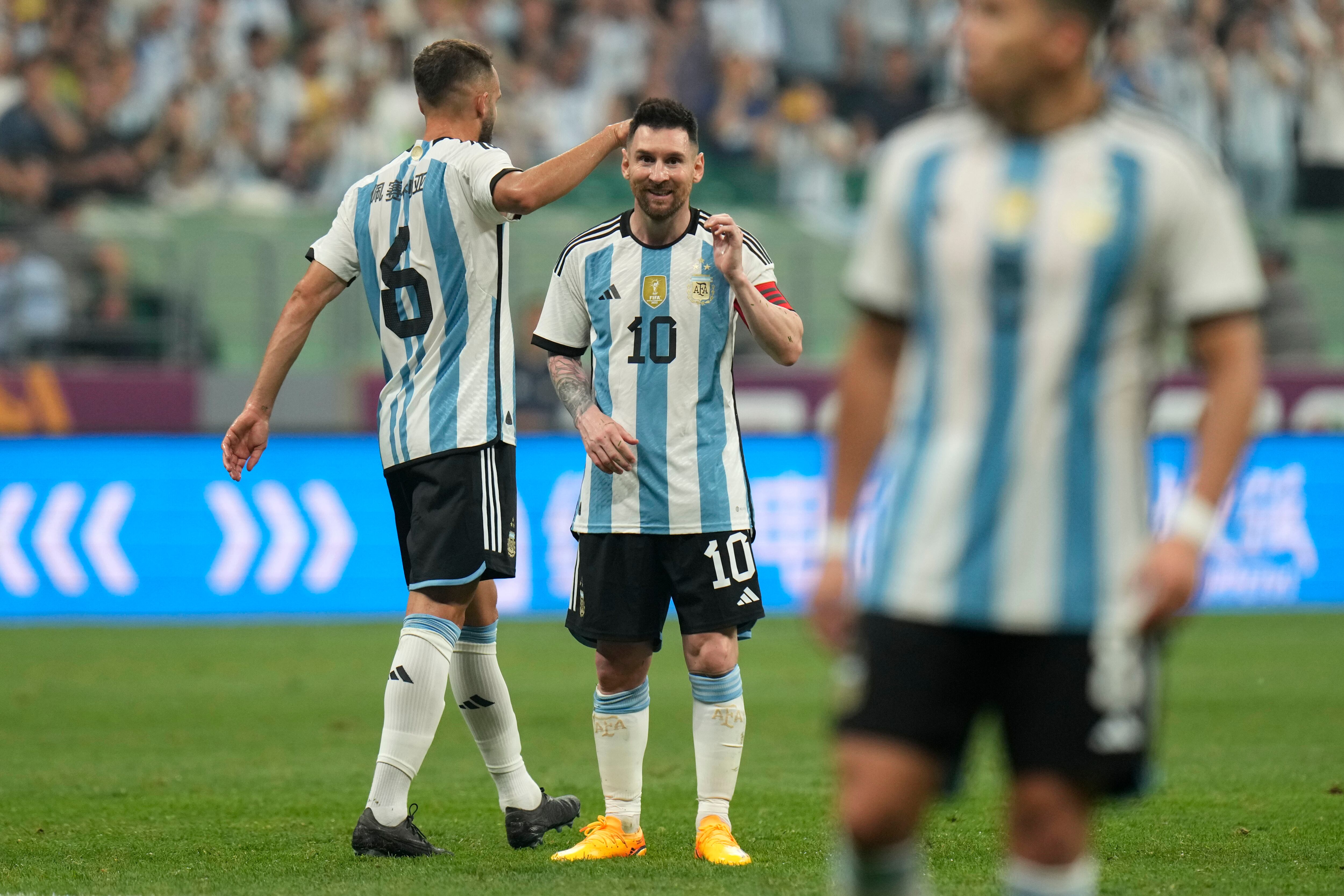Argentina's Lionel Messi, center, and German Pezzela, left, reacts during during their friendly soccer match against Australia at the Workers' Stadium in Beijing, China, Thursday, June 15, 2023. (AP Photo/Andy Wong)
