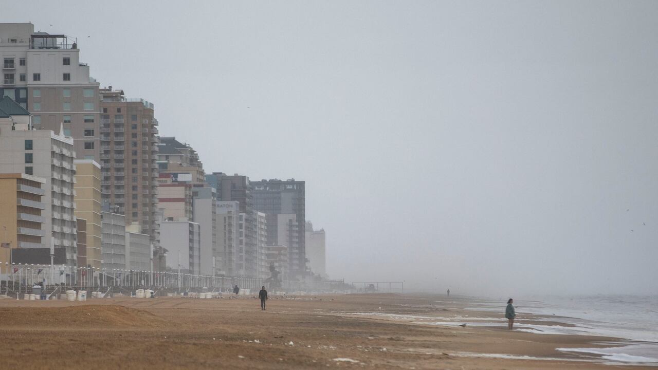 Los bañistas desafían el clima y caminan por la arena en Virginia Beach Oceanfront el viernes 22 de septiembre de 2023, mientras la tormenta tropical Ofelia se acerca en Virginia Beach, Virginia. La tormenta estaba ganando fuerza a medida que avanzaba hacia la costa de Carolina del Norte el Viernes, prometiendo un fin de semana de fuertes lluvias y viento en todo el Atlántico medio. (Kendall Warner/The Virginian-Pilot vía AP)