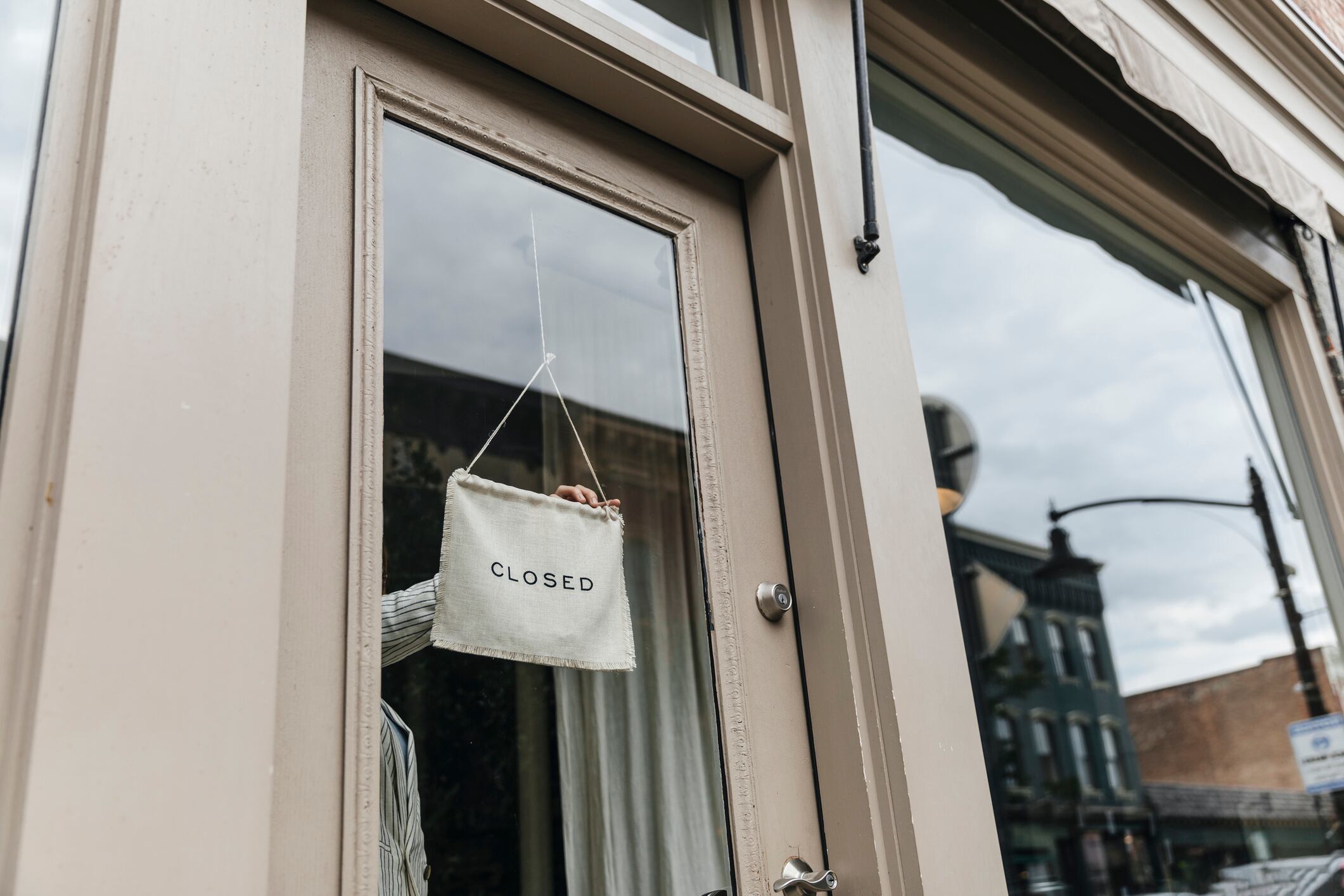 Woman turning a closed sign in shop window
