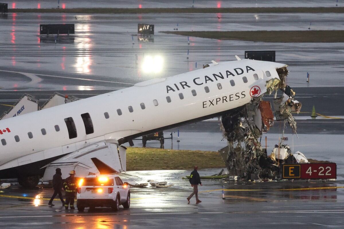 Un CRJ-900 de Air Canada Express se encuentra en la pista después de chocar con un camión de bomberos de la Autoridad Portuaria en el aeropuerto LaGuardia de Nueva York, el 23 de marzo de 2026. Un avión que transportaba a decenas de personas chocó con un camión de bomberos en una pista del aeropuerto LaGuardia de Nueva York, matando al piloto y al copiloto y causando "heridas graves" a otras personas, dijeron las autoridades el lunes. Debido al accidente del domingo por la noche, las autoridades de aviación estadounidenses detuvieron todos los vuelos en LaGuardia, y la autoridad portuaria dijo que el aeropuerto permanecería cerrado al menos hasta las 2:00 pm (1800 GMT) "para permitir una investigación exhaustiva"