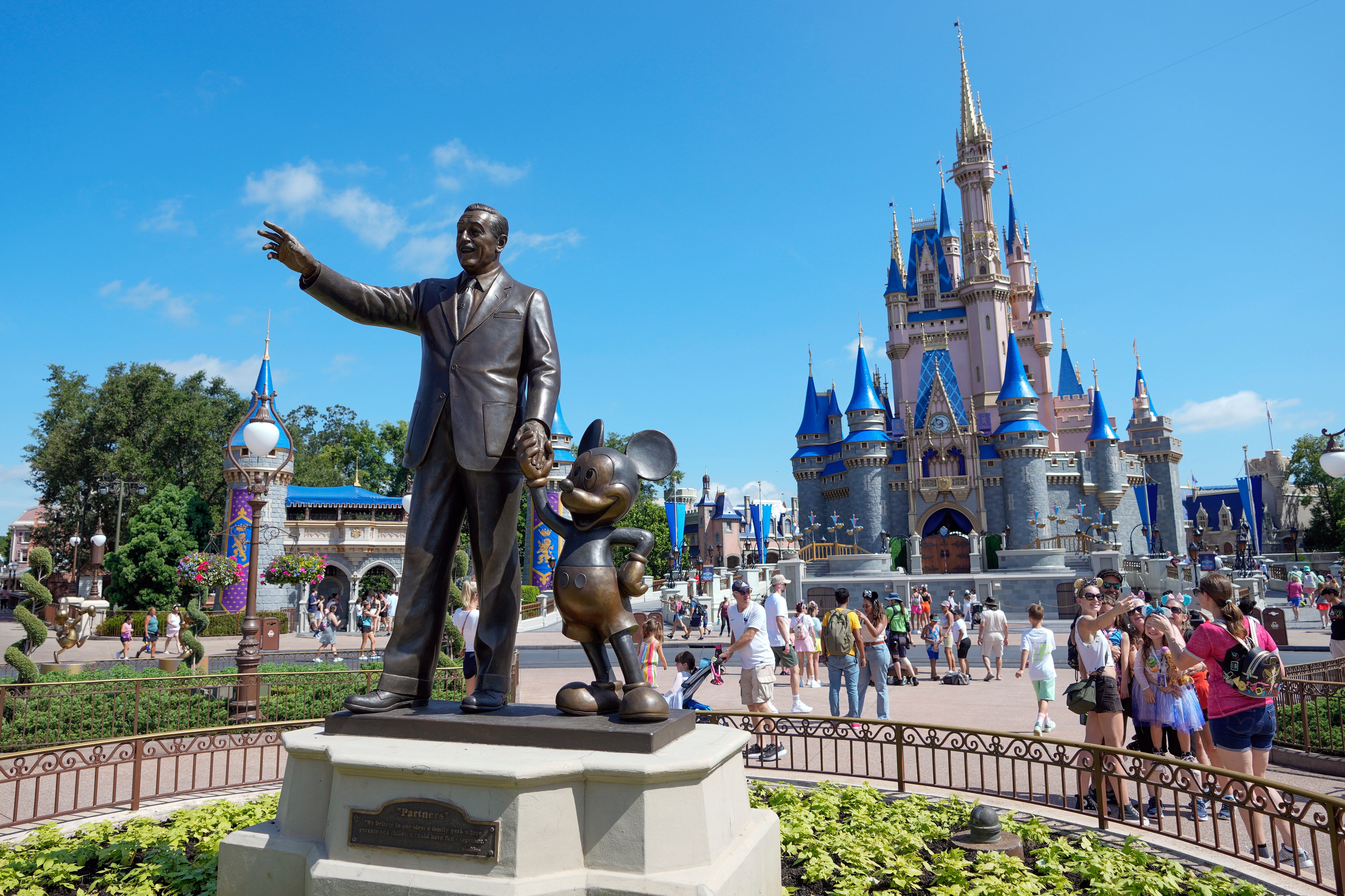 ARCHIVO - Los visitantes pasan junto a una estatua de Walt Disney y Mickey Mouse en el Reino Mágico de Walt Disney World el 14 de julio de 2023, en Lake Buena Vista, Florida (Foto AP/John Raoux, Archivo)