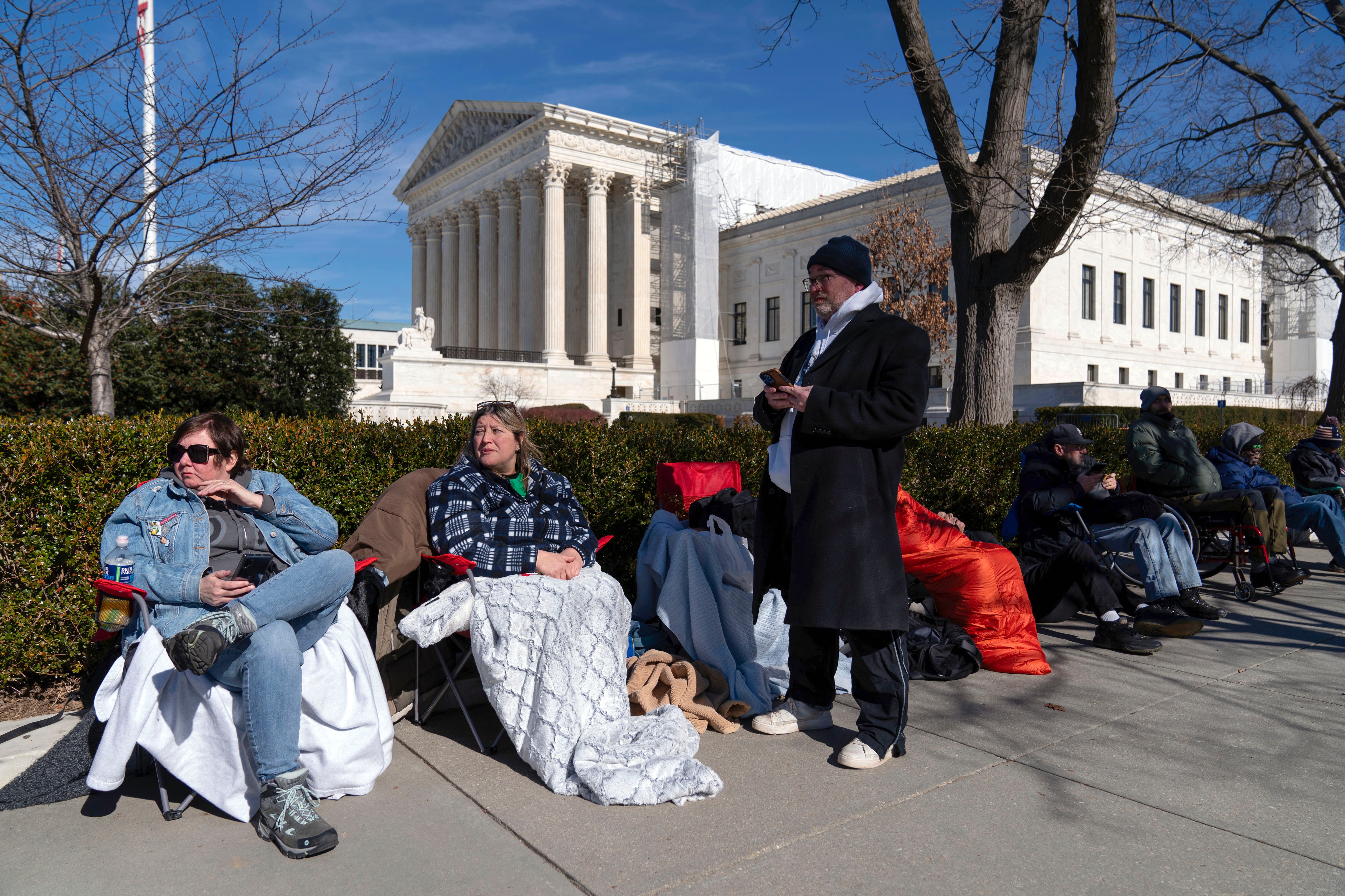 Gente hace fila frente a la Corte Suprema de EEUU para poder asistir a la audiencia que decidirá si el expresidente Donald Trump está inhabilitado para presentarse como candidato en 2024, 7 de febrero de 2024, en Washington. (AP Foto/Jose Luis Magana)