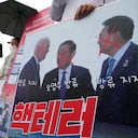 Un manifestante sostiene una pancarta que muestra una imagen del presidente estadounidense Joe Biden (izquierda), el primer ministro japonés Fumio Kishida y el presidente surcoreano Yoon Suk Yeol (derecha) durante una manifestación para oponerse a los ejercicios militares conjuntos entre Estados Unidos y Corea del Sur, cerca de la Embajada de Estados Unidos en Seúl, Corea del Sur, martes 29 de agosto de 2023. (Foto AP/Ahn Young-joon)