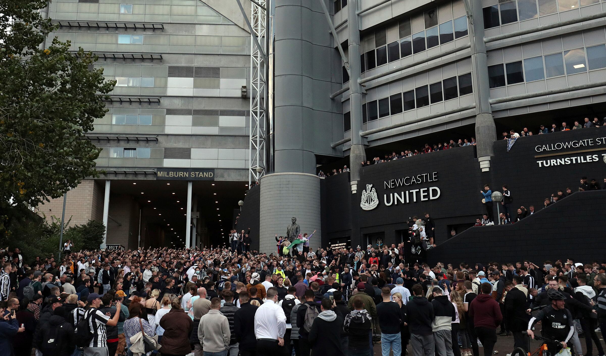 Newcastle United supporters celebrate outside St. James' Park in Newcastle Upon Tyne, England Thursday Oct. 7, 2021. English Premier League club Newcastle has been sold to Saudi Arabia’s sovereign wealth fund after a protracted takeover and legal fight involving concerns about piracy and rights abuses in the kingdom. (AP Photo/Scott Heppell)