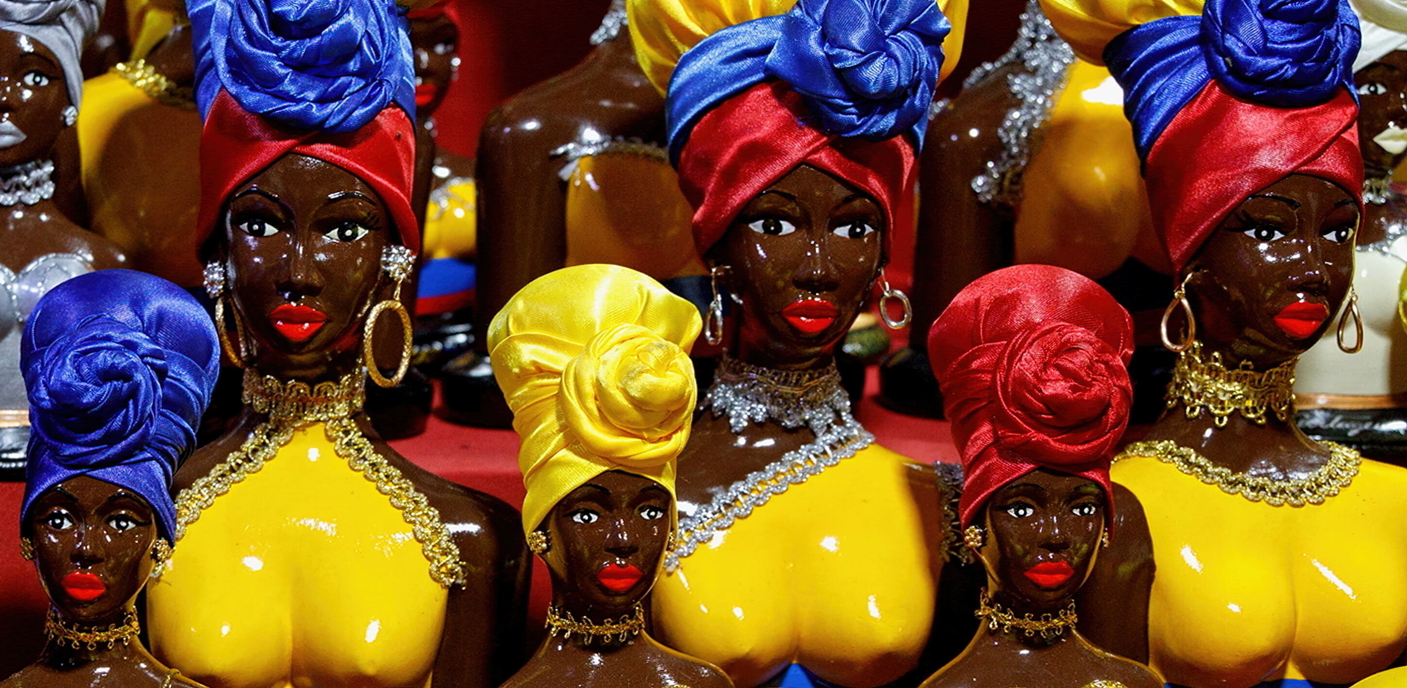 Muñecas palenqueras colombianas de colores brillantes a la venta en un mercado de recuerdos al aire libre de Cartagena, Colombia.